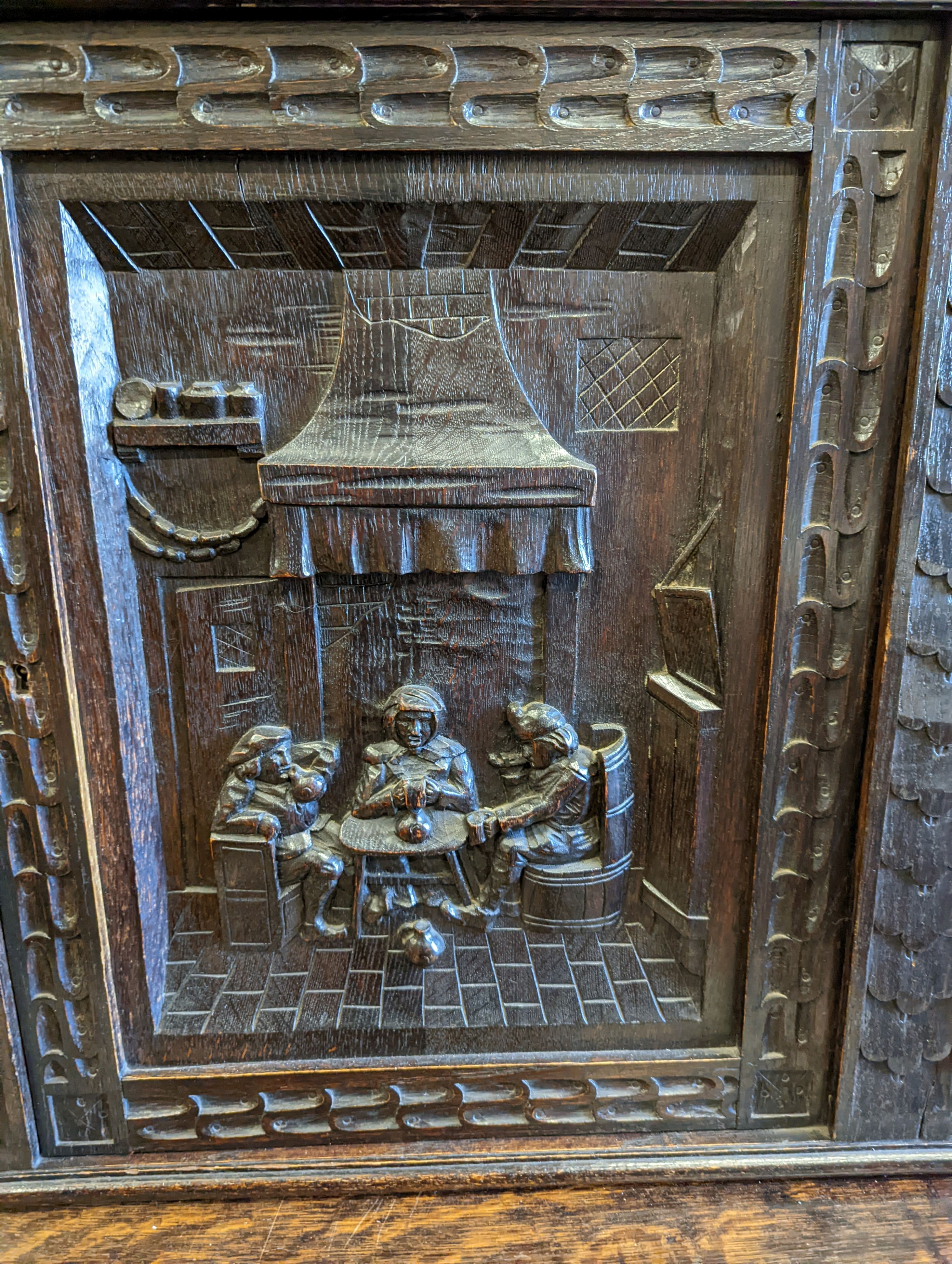 An early 20th century carved oak court cupboard in the Flemish style, length 200cm, depth 58cm, height 212cm
